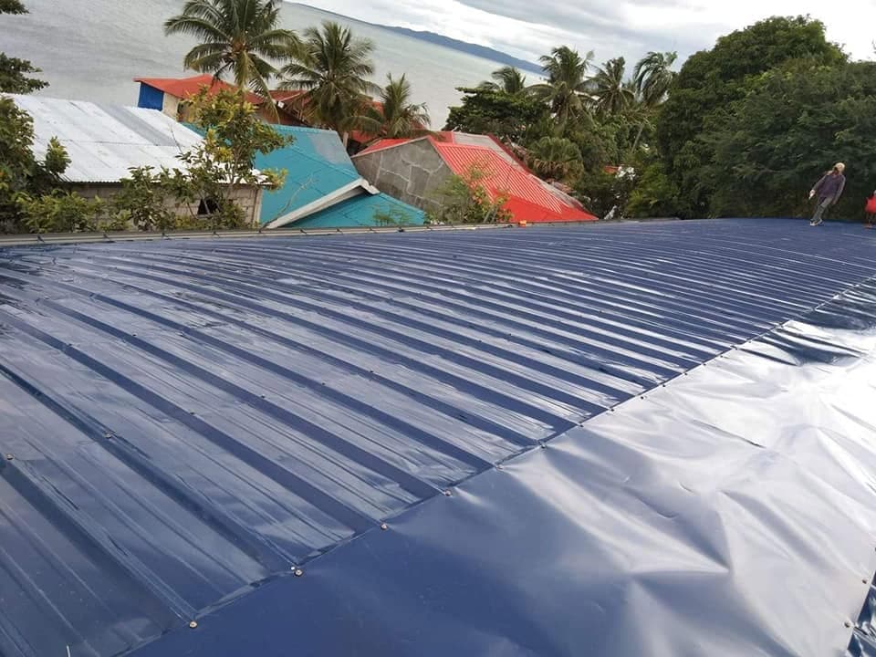 Blue corrugated roofing installed on a building near the sea