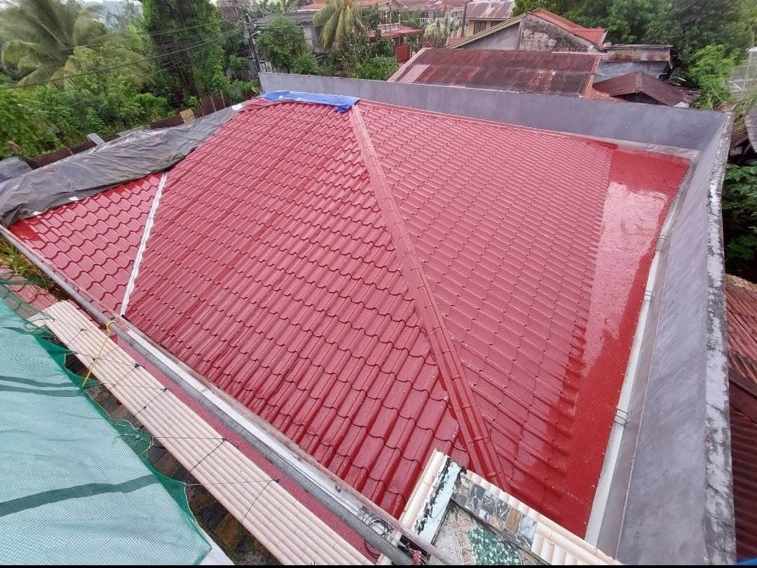 Newly installed red tile-profile metal roof on a house
